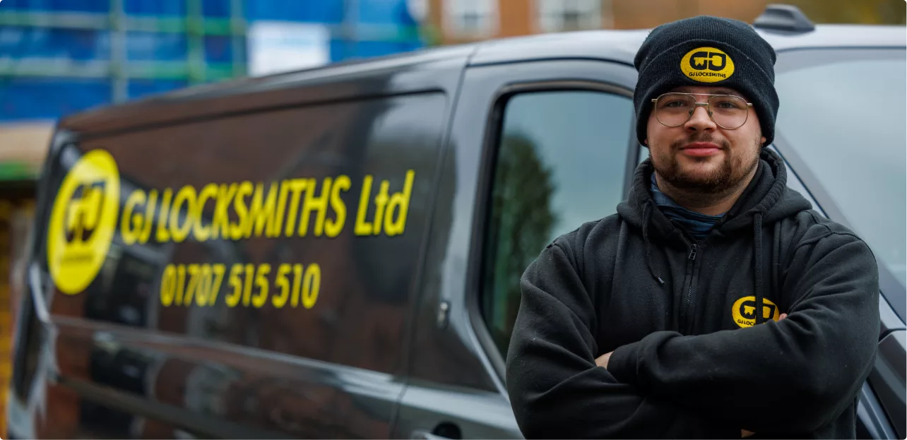 A GJ Locksmith standing by his van